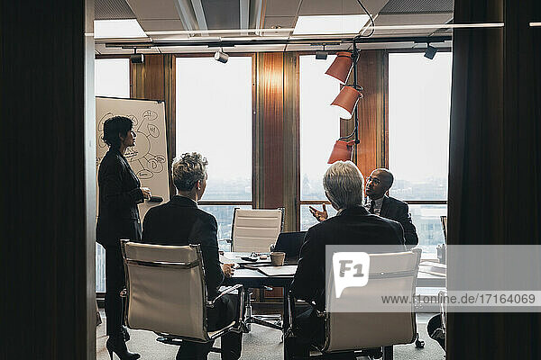 Business colleagues planning strategy during meeting in board room at office