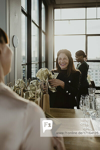 Lächelnde Geschäftsfrau schaut auf weibliche Kollegin im Büro