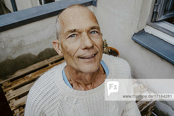 Porträt eines lächelnden Seniors auf dem Balkon