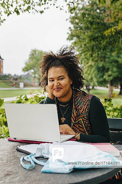 Lächelnde Studentin mit Laptop in College-Campus