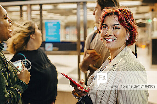 Lächelnde männliche und weibliche Studenten an der U-Bahn-Station