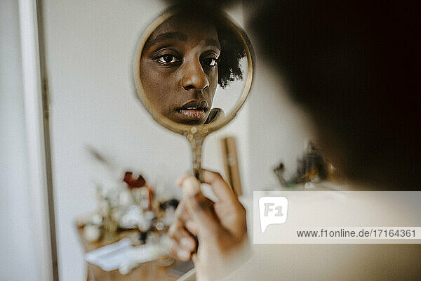 Reflexion der besorgten Frau in der Hand Spiegel zu Hause
