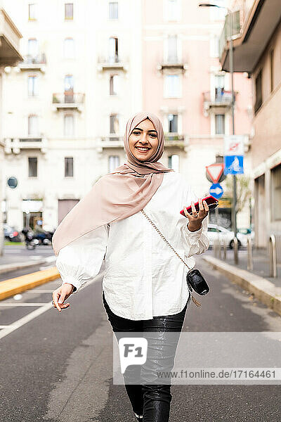 Young muslim woman walking in city