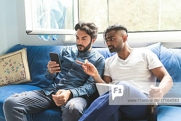 Men hanging out  looking at smart phone