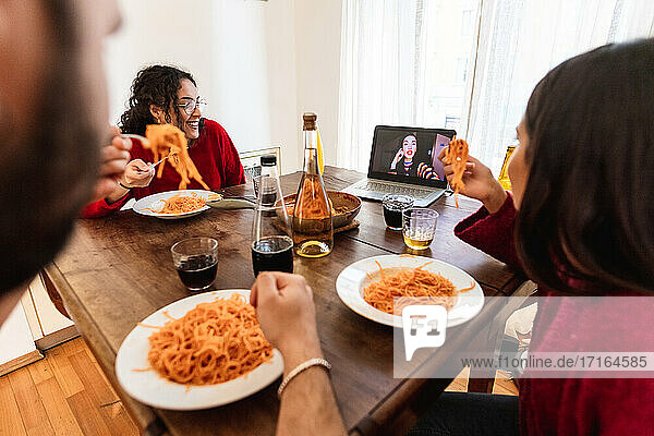 Friends having spaghetti meal and making video call