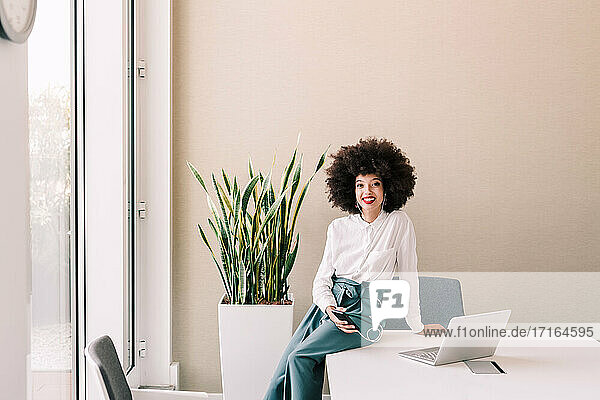 Porträt einer Geschäftsfrau im Büro mit Telefon und Laptop