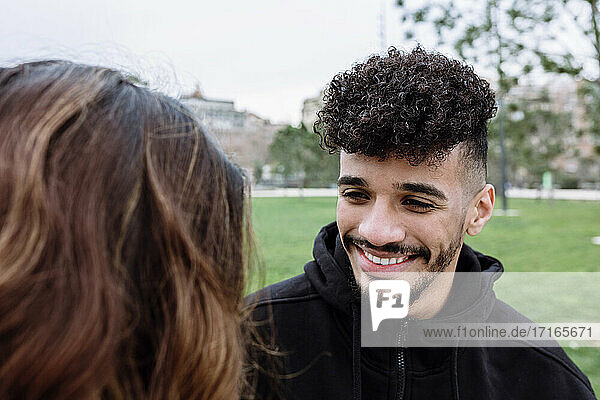 Smiling young man with female friend at public park