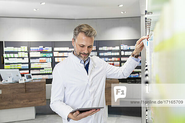 Male pharmacist doing inventory with digital tablet