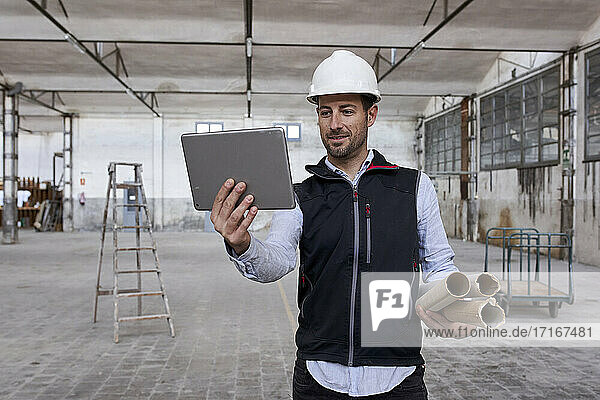 Male real estate developer using digital tablet while working in building