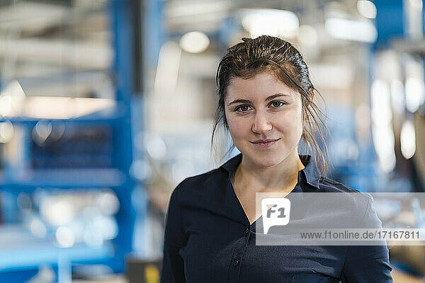 Young businesswoman staring while standing at industry
