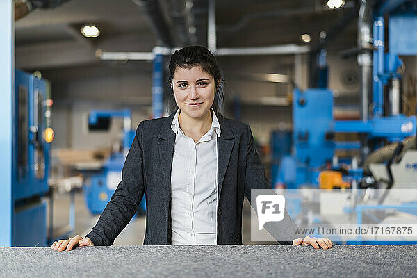 Young businesswoman smiling while standing at industry