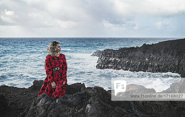 Junger Tourist schaut weg  während er in Los Hervideros  Lanzarote  Spanien  am Meer steht