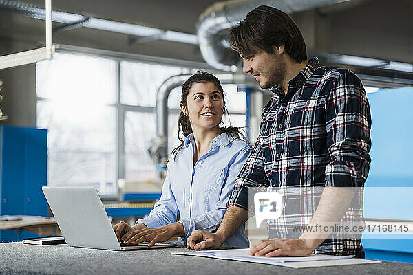 Expertise team working over laptop while standing at industry