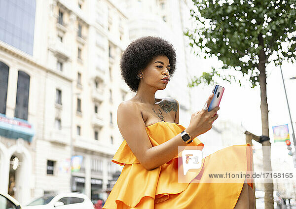 Hispanic woman using mobile phone in city