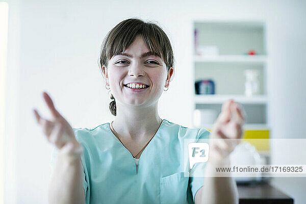 Smiling female nurse gesturing in hospital
