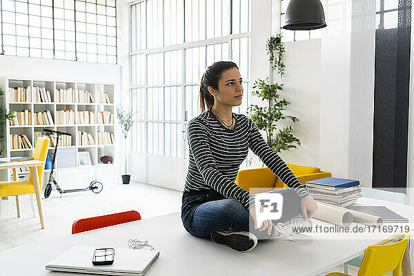 Kreative Geschäftsfrau  die im Büro am Tablet sitzt und nachdenkt