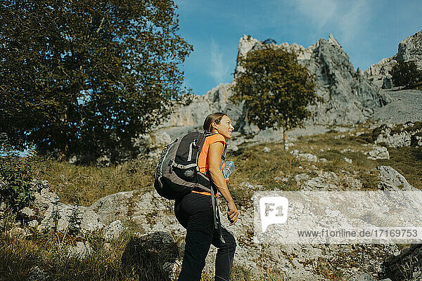 Female hiker wearing backpack hiking on Cares Trail at Picos De Europe National Park  Asturias  Spain