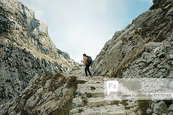 Female explorer with backpack walking on mountain of Cares Trail  Picos De Europe National Park at Asturias  Spain