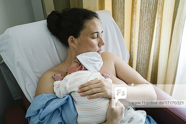 Mutter umarmt neugeborenen Jungen beim Ausruhen