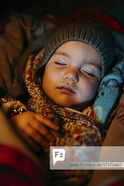 Baby-Mädchen mit Strickmütze beim Schlafen im Winter