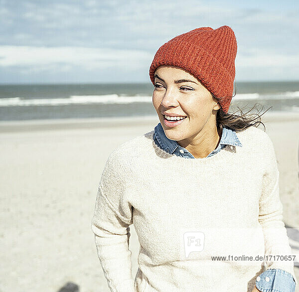 Porträt einer Frau mit Strickmütze am Strand