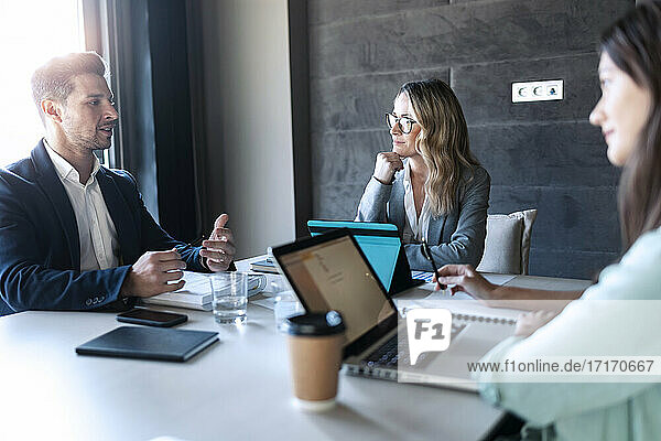 Business people having discussion while sitting in meeting at office