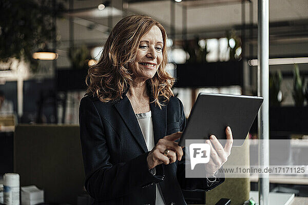 Unternehmerin nutzt digitales Tablet im Büro