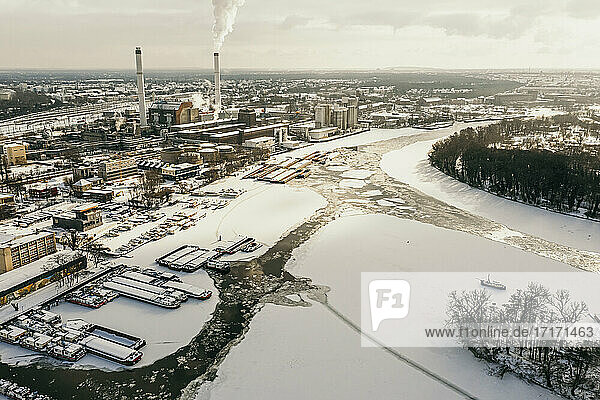 Germany  Berlin  Smoking power plant chimney towering over frozen Spree river