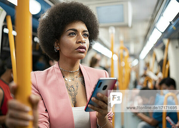 Afro woman with smart phone in train