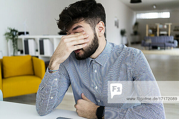 Tired businessman sitting in office