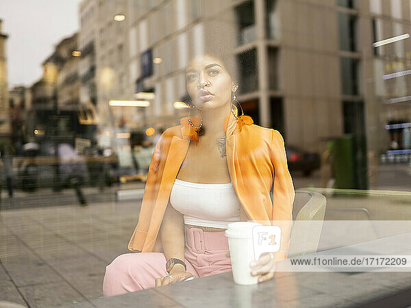 Young woman contemplating with coffee cup in cafe