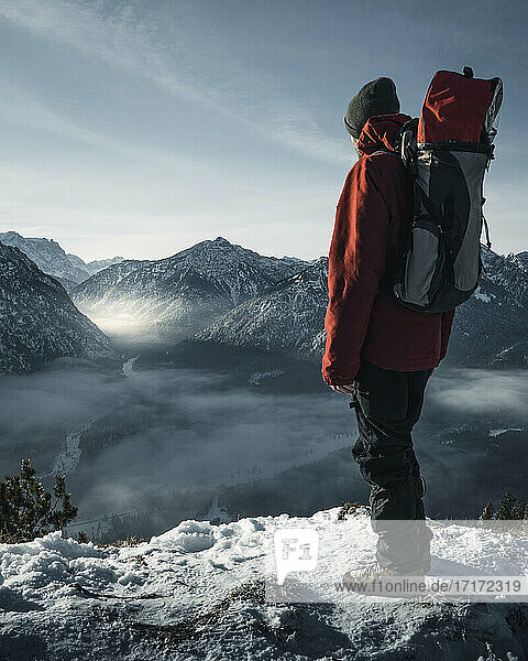 Germany  Bavaria  Ammergau Alps  Teufelstattkopf  Tourist hiking in mountains on winter day