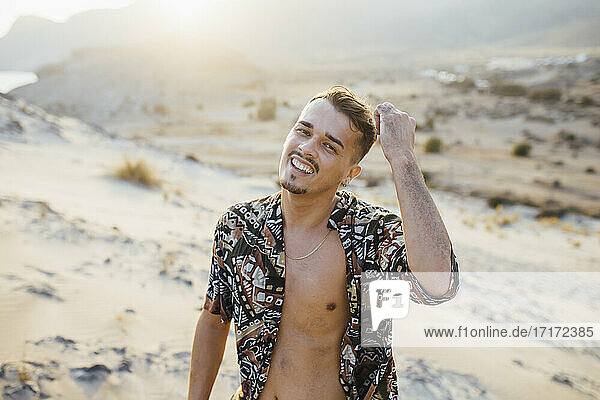 Glücklicher gut aussehender Mann mit aufgeknöpftem Hemd in der Wüste in Almeria  Tabernas  Spanien