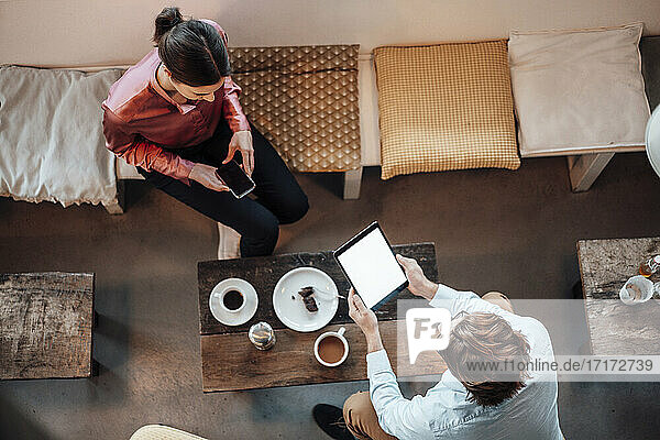Geschäftsfrau  die sich mit einem männlichen Mitarbeiter trifft  während sie in einem Café sitzt