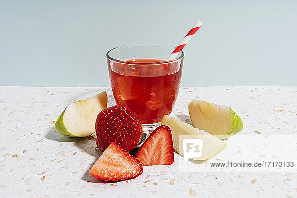 Healthy fruit juice with strawberry and apple on modern terrazzo marble against wall at home