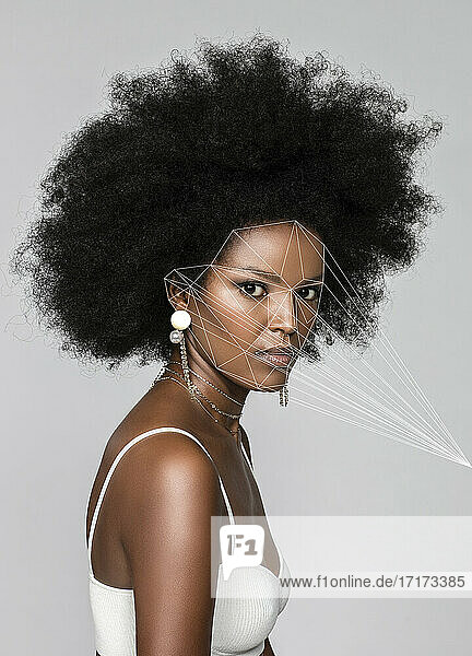 Afro woman with facial recognition laser beams against white background