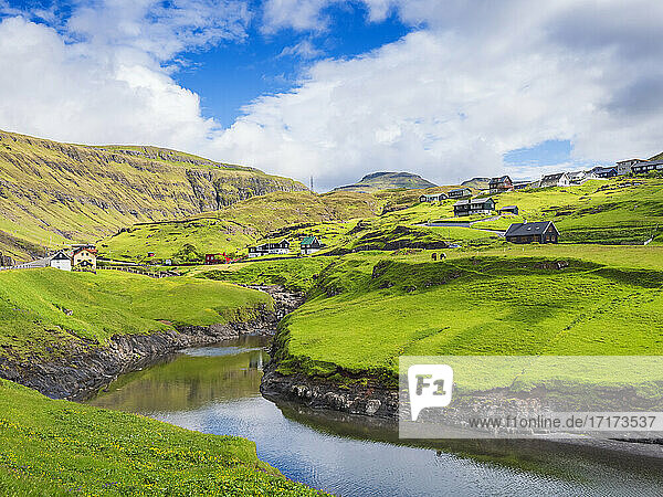 Houses over meadow in Leynar village against sky  Iceland