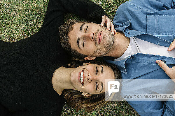 Lächelndes Paar auf dem Rasen liegend