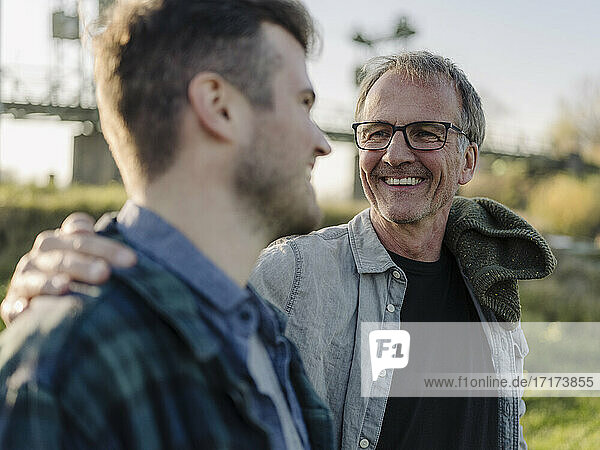 Smiling father talking with son outdoors