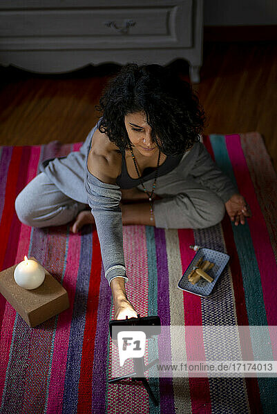 Spiritual woman adjusting mobile phone during video call at home