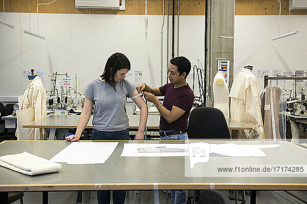 Fashion students  man measuring woman's arm