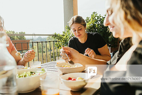 Freunde essen eine Mahlzeit auf dem Balkon