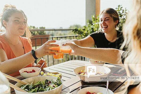 Friends toasting with glasses of juice