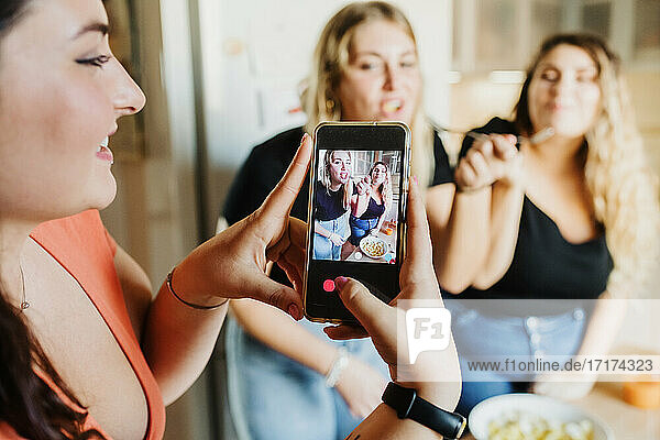 Woman taking video of her friends eating