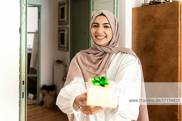 Junge muslimische Frau gibt ein Geschenk
