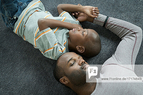 Vater und Sohn liegen schlafend auf dem Boden