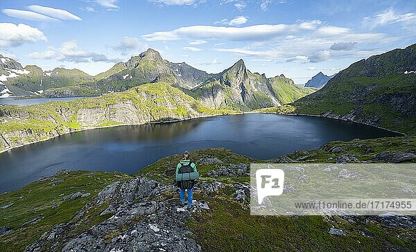 Junge Frau mit Rucksack  Berglandschaft mit See Tennesvatnet  Wanderung zum Munken  Moskenesöy  Lofoten  Nordland  Norwegen  Europa