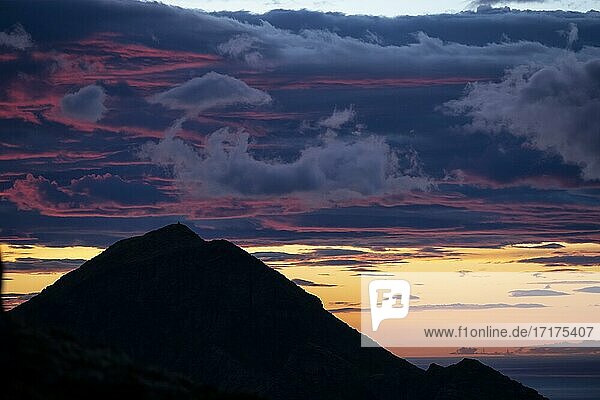 Glühender Abendhimmel über Berggipfel  Abendrot  dramatische Abendstimmung  Sonnenuntergang mit Wolken über dem Meer  Blick vom Gipfel des Hermannsdalstinden  Moskenesöy  Lofoten  Nordland  Norwegen  Europa