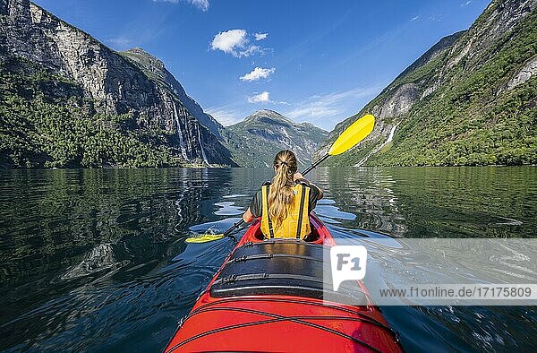 Young woman paddling in a kayak  Geirangerfjord  near Geiranger  Norway  Europe