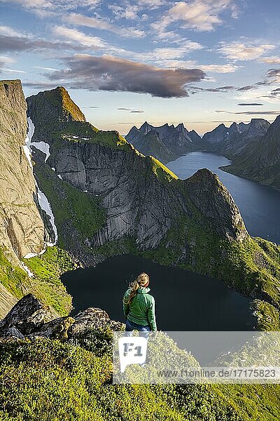 Junge Wanderin genießt Aussicht vom Reinebringen  Reinebriggen  Reinefjord mit Bergen  Moskenes  Moskenesöy  Lofoten  Norwegen  Europa